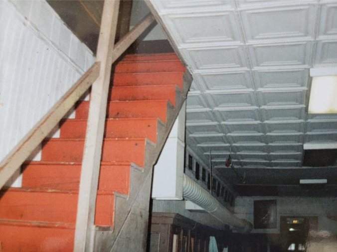 Image 15 - (BEFORE) The descending stairs from the third floor into the old locker room in what is now the Erg Room and social space. The wall on the left was removed to make one large space.